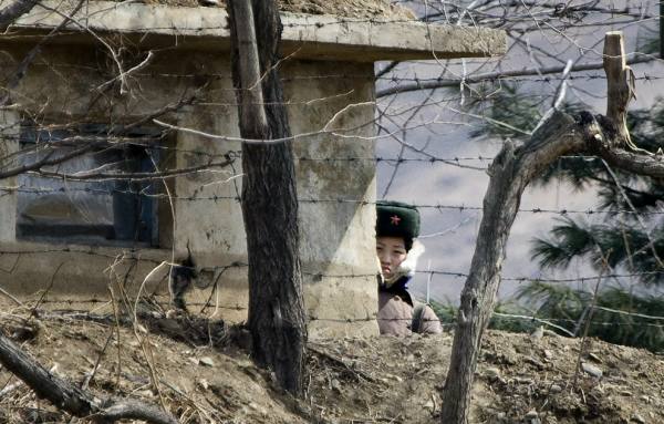 A North Korean soldier stands watch from behind her guard post on the waterfront of the Yalu River (AP Photo/Andy Wong)